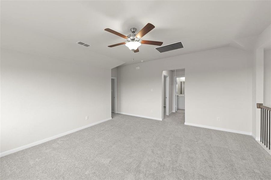 Empty room featuring carpet, ceiling fan, and vaulted ceiling