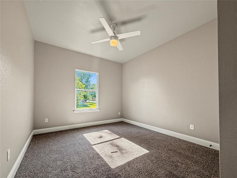 Room featuring neutral wall tones, gray carpeting, and a ceiling fan with integrated lighting Room featuring neutral wall tones, gray carpeting, and a ceiling fan with integrated lighting