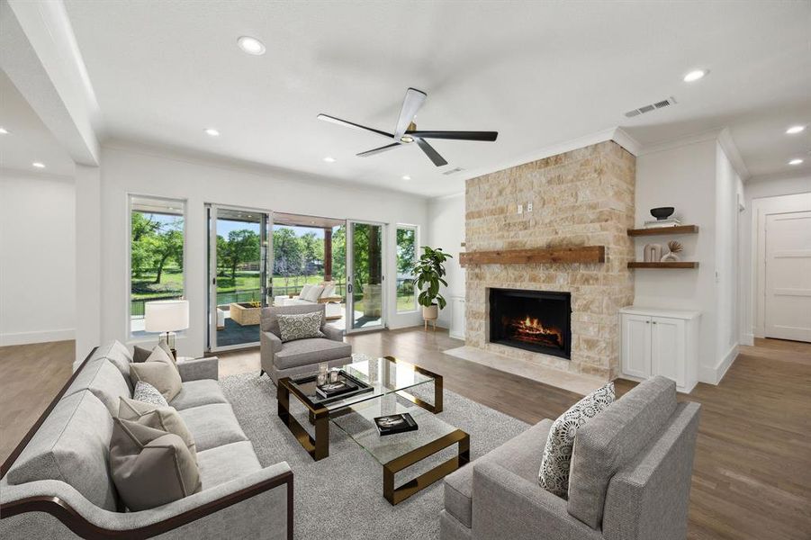 Living room featuring light wood-style floors, crown molding, a stone fireplace, recessed lighting, and a ceiling fan Living room featuring light wood-style floors, crown molding, a stone fireplace, recessed lighting, and a ceiling fan