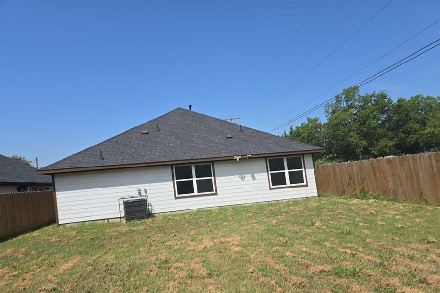 Rear view of property with a fenced backyard and roof with shingles Rear view of property with a fenced backyard and roof with shingles