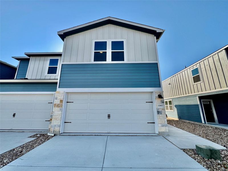View of front of home featuring board and batten siding, stone siding, and a garage View of front of home featuring board and batten siding, stone siding, and a garage