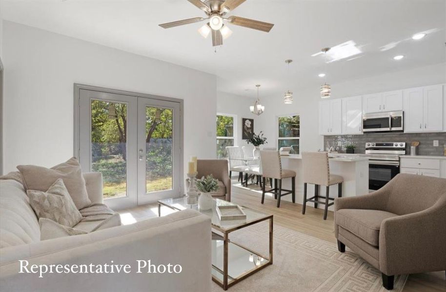 Living room featuring french doors, light hardwood / wood-style flooring, and ceiling fan with notable chandelier