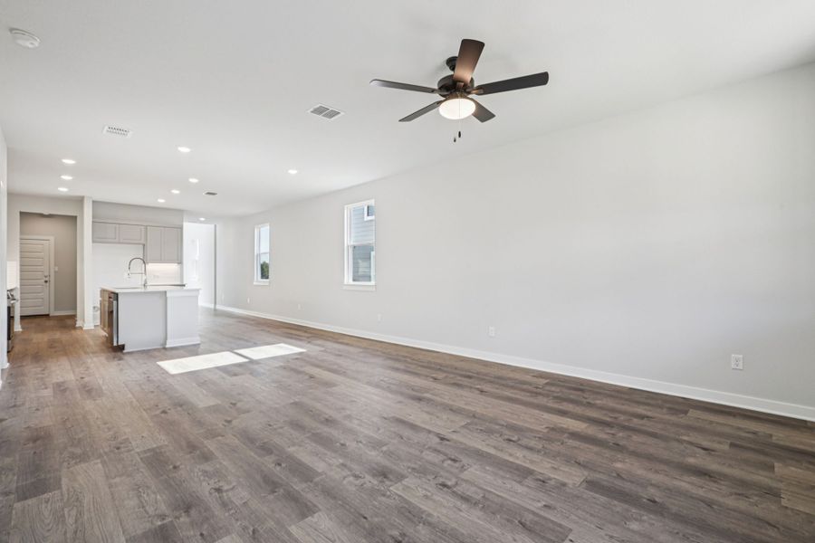 A room with a wood floor and a ceiling fan.
