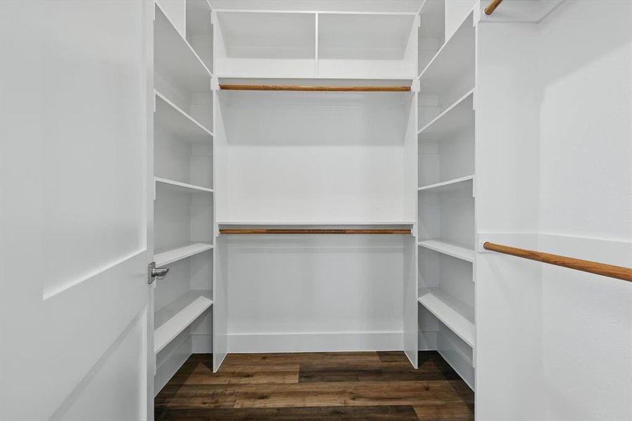 Spacious closet with dark wood-style floors