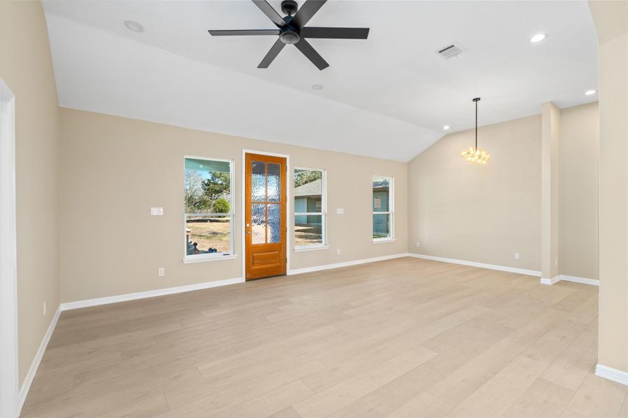 Step into a sun-filled livingarea with vaulted ceilings,sleek recessed lighting, and amodern black ceiling fan.Light hardwood floors andneutral tones create an open,inviting space perfect forentertaining.