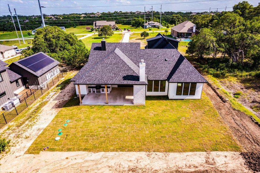A new build with a spacious covered patio overlooking a verdant lawn.