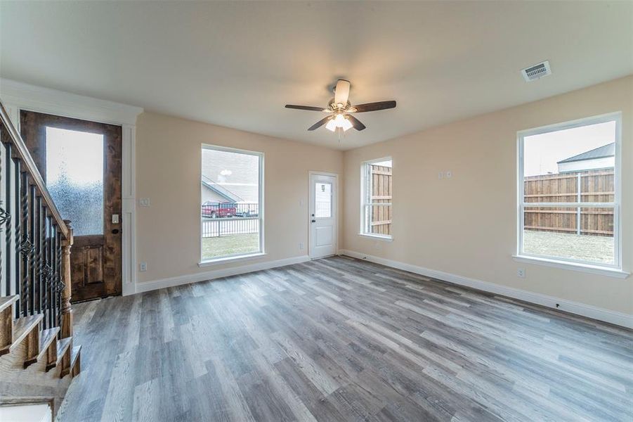 Unfurnished living room with ceiling fan and hardwood / wood-style flooring