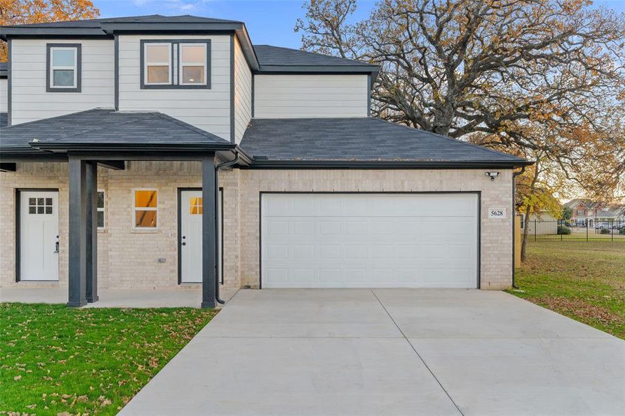 View of front property featuring a front yard and a garage