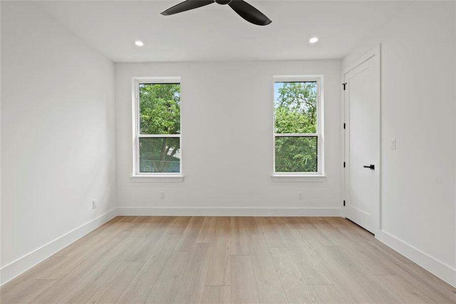 Spare room featuring light wood-style floors, a ceiling fan, and recessed lighting