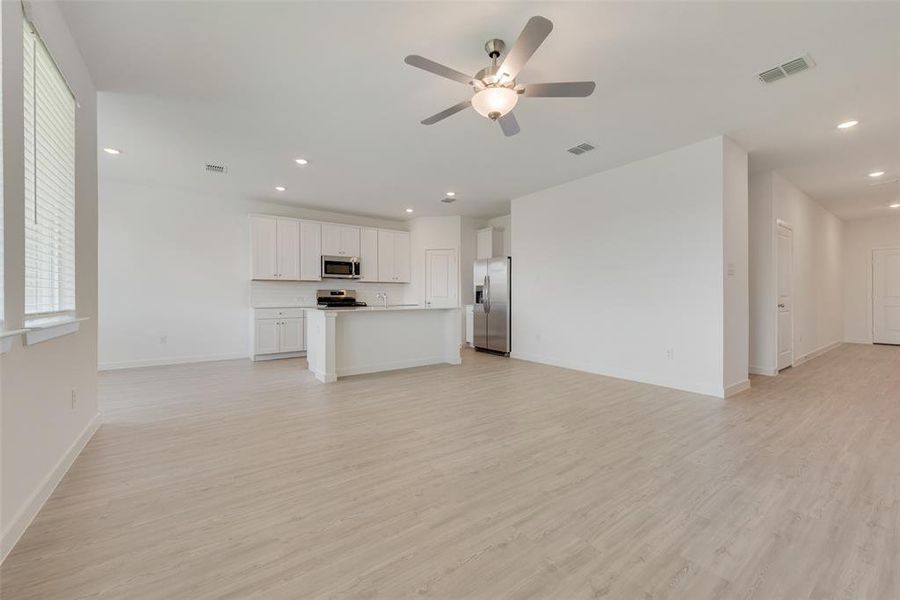 Unfurnished living room with light hardwood / wood-style floors and ceiling fan