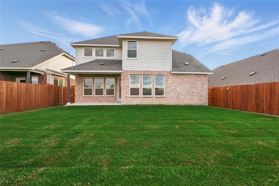 Back of house featuring a shingled roof, brick siding, and a patio area Back of house featuring a shingled roof, brick siding, and a patio area