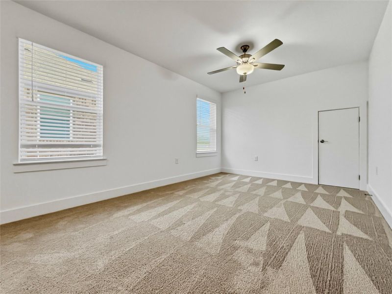 Bedroom with light carpet and a ceiling fan