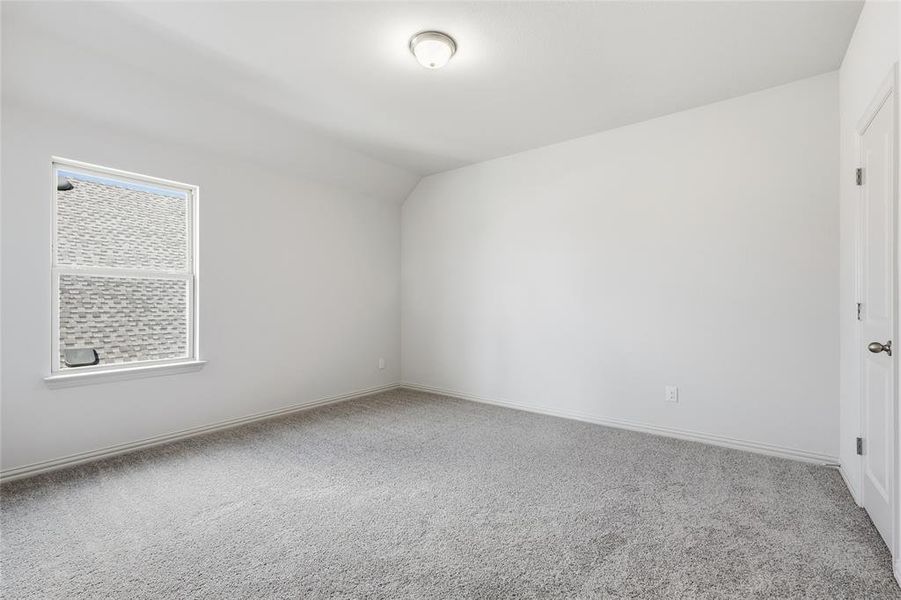 Unfurnished room featuring vaulted ceiling and light carpet Unfurnished room featuring vaulted ceiling and light carpet