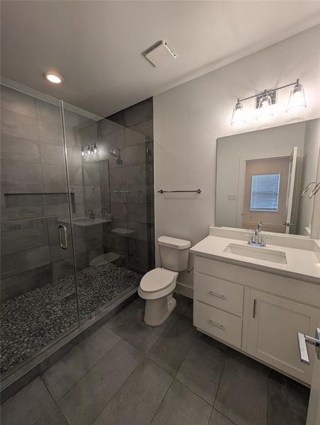 Bathroom with tile patterned floors, vanity, and a shower stall