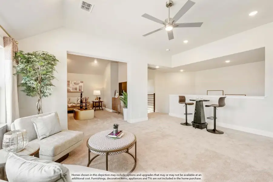 Open loft area with carpet, ceiling fan, bar-height table, and seating that overlooks a living room below.