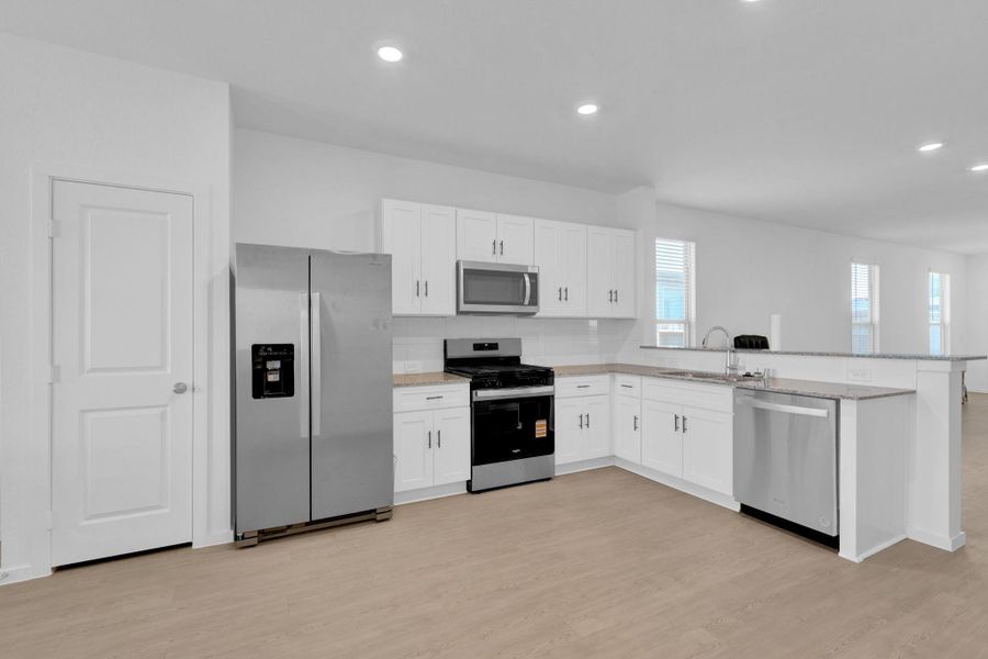 Great gas kitchen with stainless steel appliances, stove, dishwasher and refrigerator overlooking family room