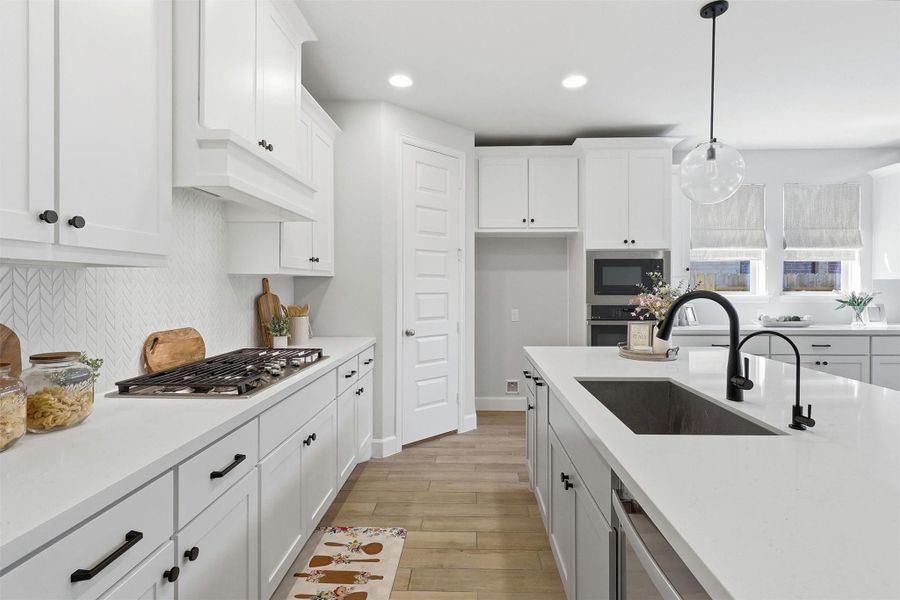 Designed with both style and functionality in mind, the kitchen features abundant shaker cabinetry, sleek quartz countertops, a spacious center island with seating, an undermount sink, and a convenient reverse osmosis water system. Every detail has been thoughtfully selected to elevate everyday living.