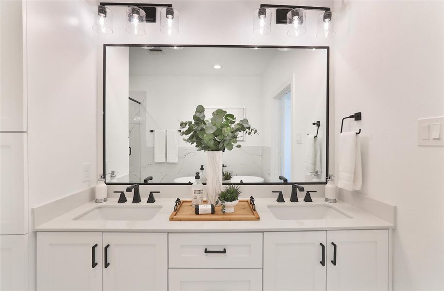 A double vanity with ample space to accommodate all your storage needs in the primary bathroom. A double vanity with ample space to accommodate all your storage needs in the primary bathroom.