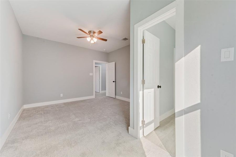 Empty room featuring light carpet and ceiling fan