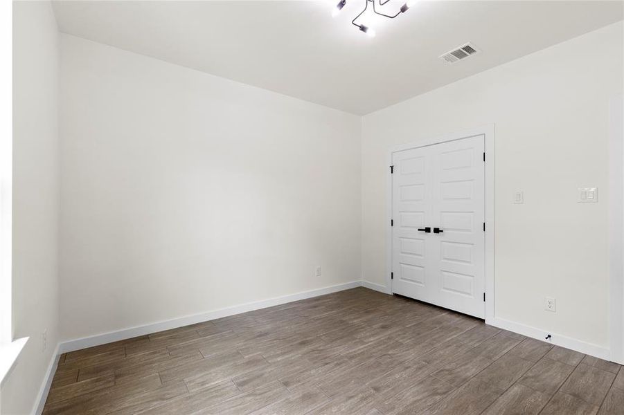 Interior room featuring wood-finish flooring, white walls, and bright white trim