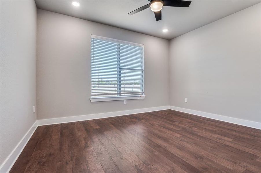 Spare room with dark wood-style floors, a ceiling fan, and recessed lighting