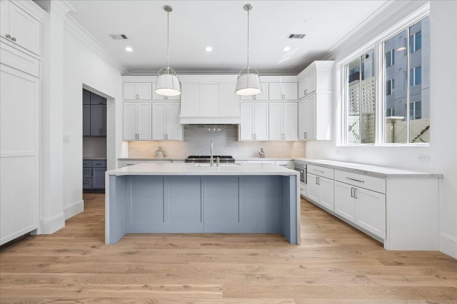 The kitchen showcases a premium Thermador appliance package, which includes a 48” Pro Harmony gas range, a 24” built-in MicroDrawer microwave, a 24” custom panel dishwasher, a 30” custom panel fresh food refrigerator, and 30” freezer columns.