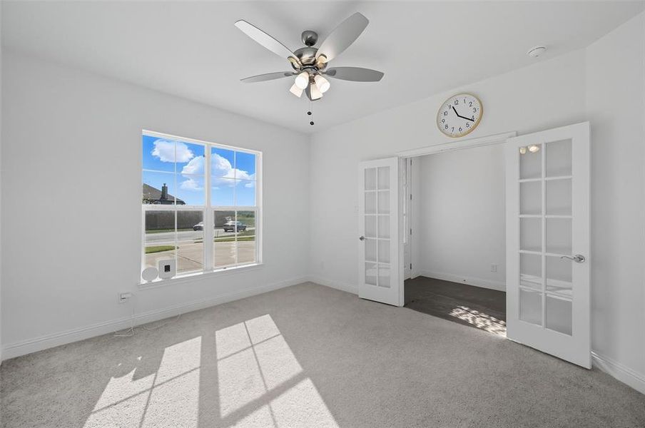 Unfurnished bedroom featuring carpet floors, french doors, and a ceiling fan