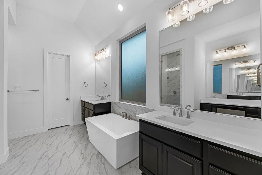 Stunning primary bathroom with double sinks and standing designer soaking tub. Stunning primary bathroom with double sinks and standing designer soaking tub.