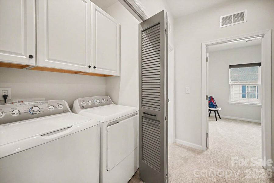 Convenient laundry area with top-load washer and dryer included