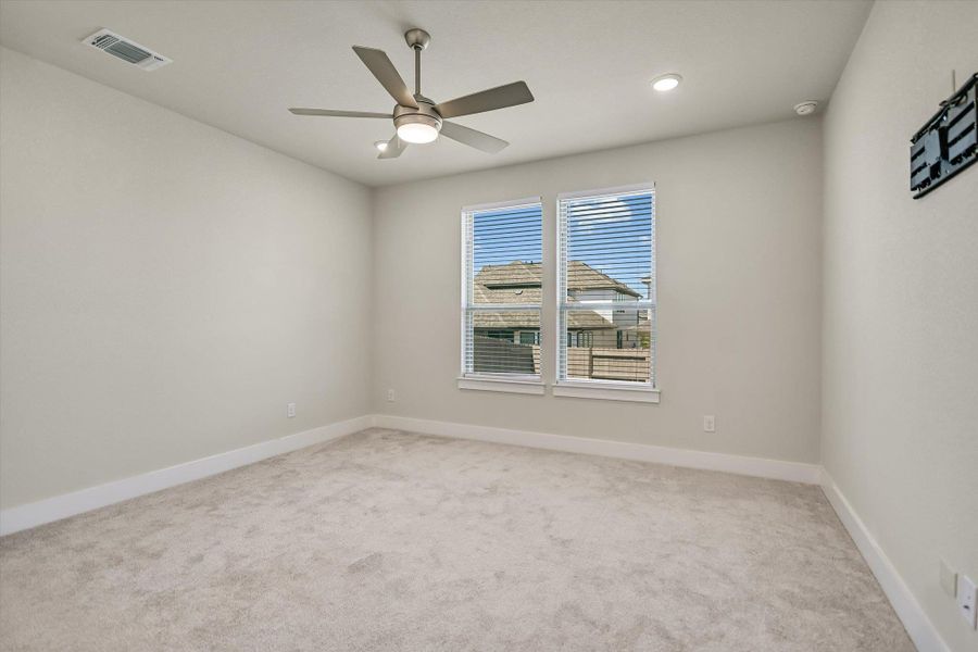 Soft carpeting pairs with tall windows in this quiet secondary bedroom. Soft carpeting pairs with tall windows in this quiet secondary bedroom.
