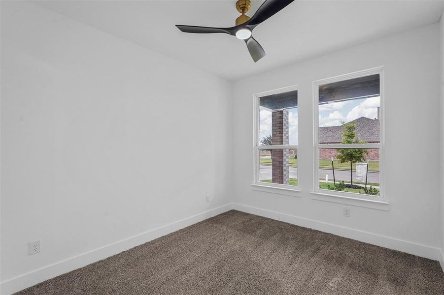 Spare room with dark colored carpet and a ceiling fan Spare room with dark colored carpet and a ceiling fan