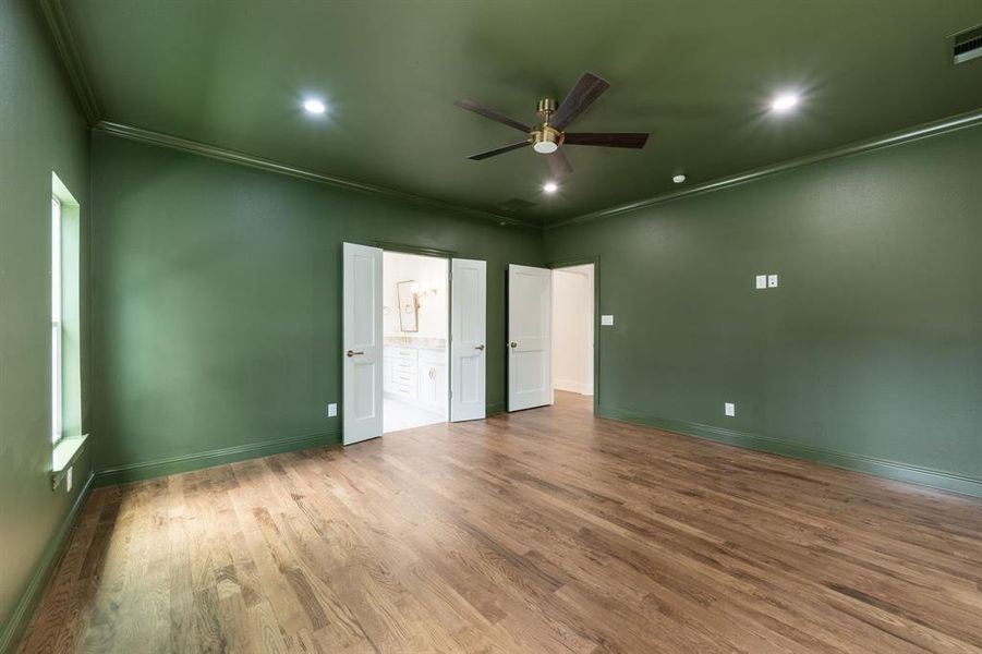 Hardwood-finish flooring extending throughout, complemented by a ceiling fan with integrated lighting, recessed lighting fixtures, and a window Hardwood-finish flooring extending throughout, complemented by a ceiling fan with integrated lighting, recessed lighting fixtures, and a window