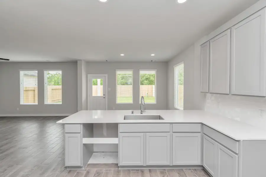 Discover another perspective of this stunning kitchen, generously appointed with an abundance of counter space. Sample photo of completed home with similar floor plan. Actual colors and selections may vary. Discover another perspective of this stunning kitchen, generously appointed with an abundance of counter space. Sample photo of completed home with similar floor plan. Actual colors and selections may vary.