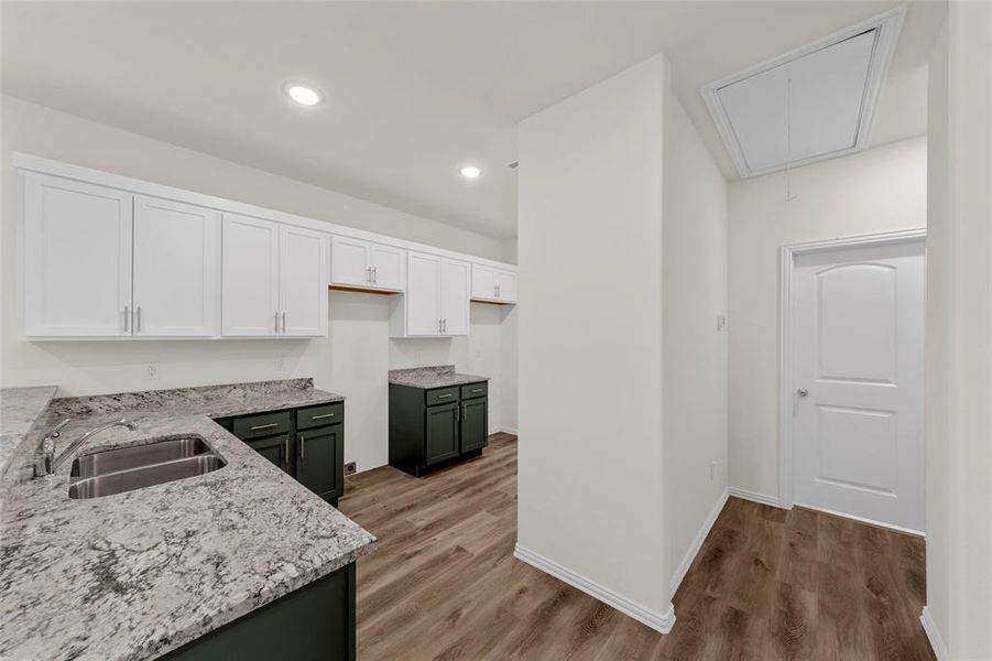 Kitchen featuring sink, white cabinets, and light hardwood / wood-style flooring