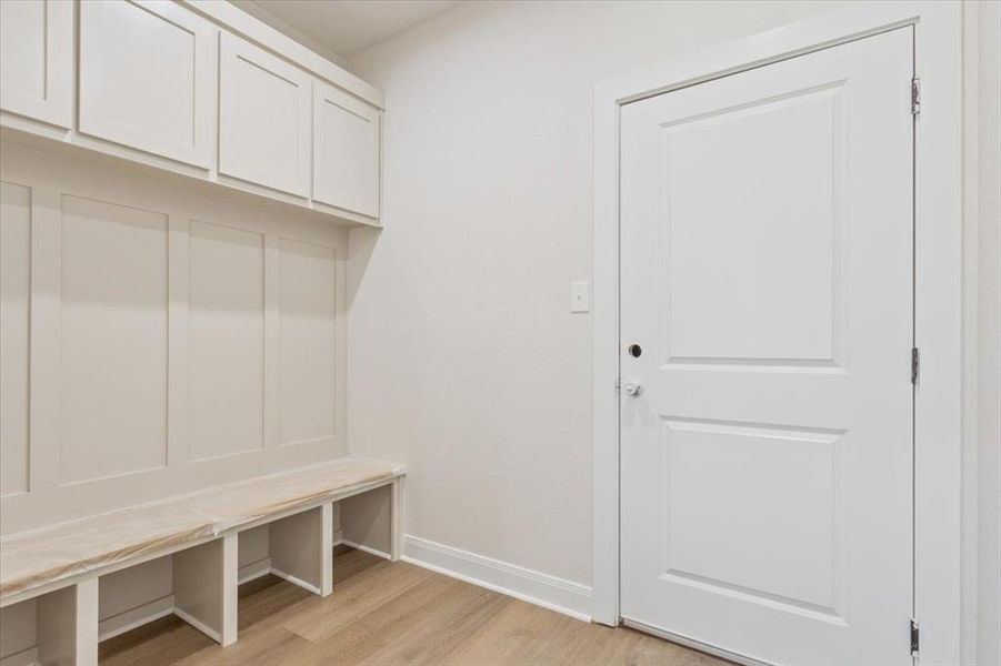 Mudroom featuring light wood-style flooring and baseboards