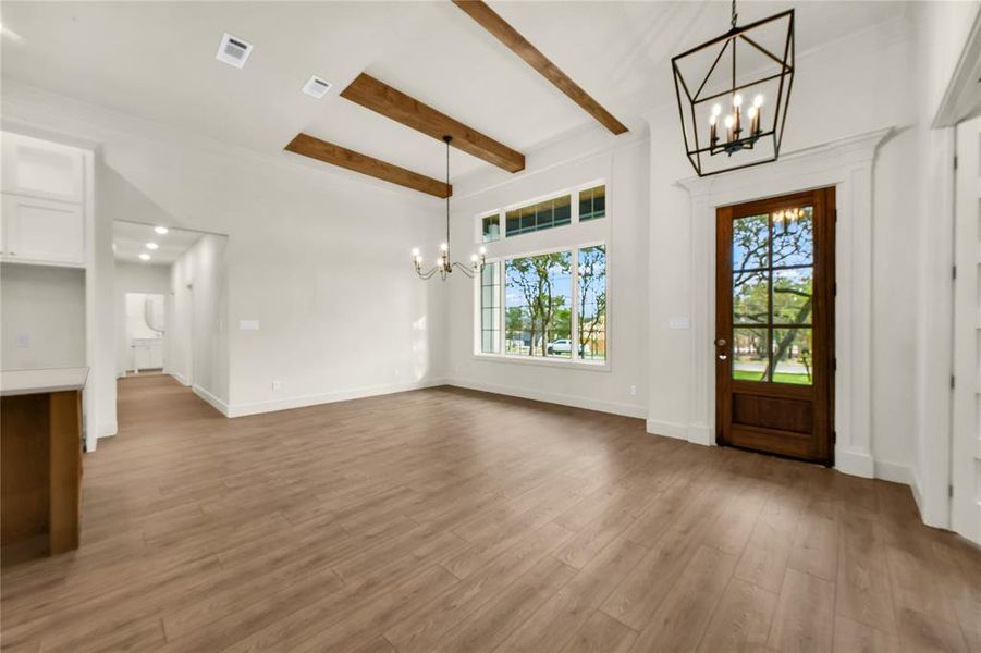 Foyer featuring a chandelier, beam ceiling, and dark wood-style flooring Foyer featuring a chandelier, beam ceiling, and dark wood-style flooring