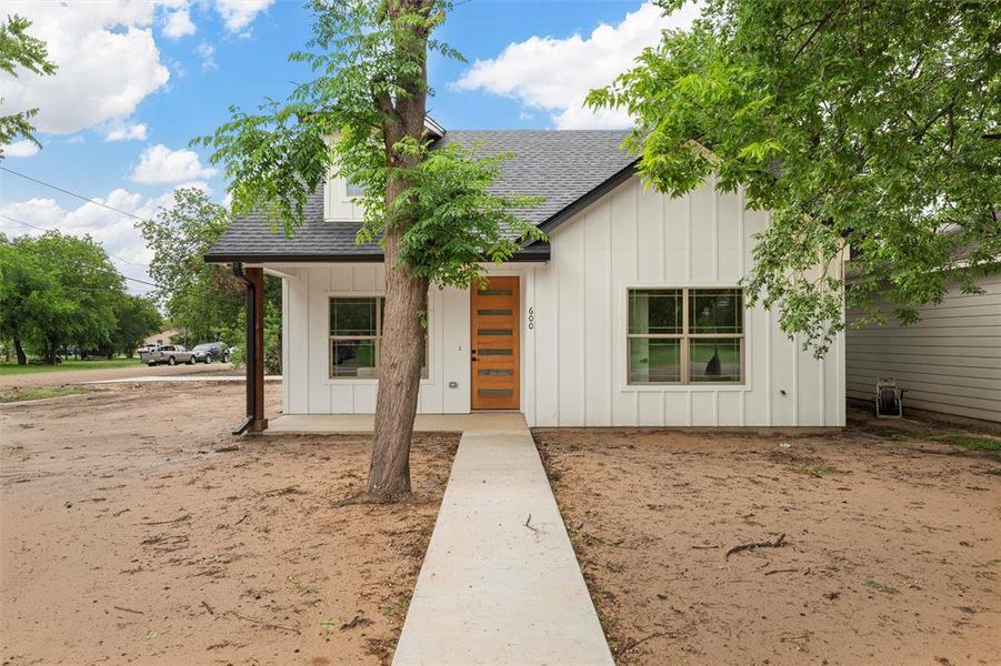 Modern inspired farmhouse featuring a shingled roof and board and batten siding