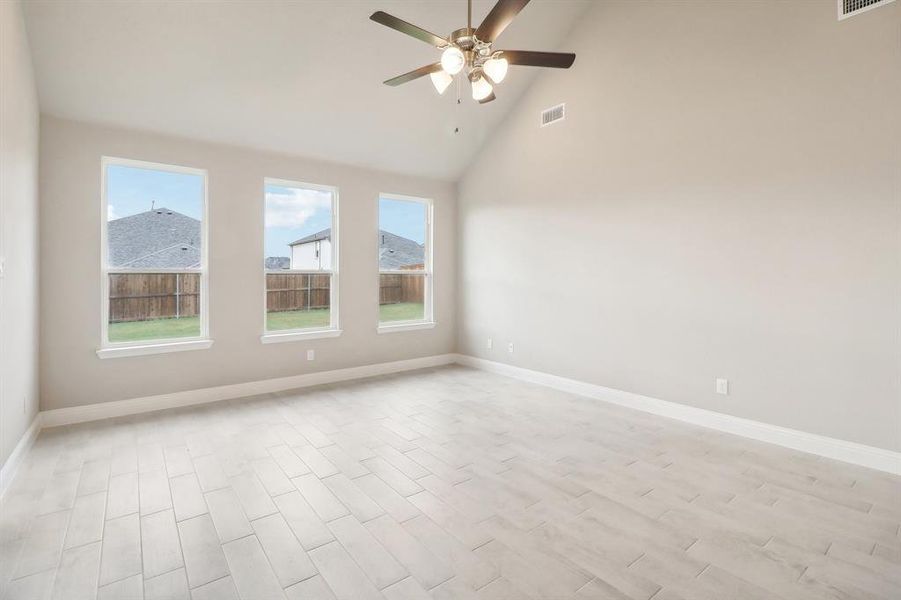 Unfurnished room with ceiling fan, plenty of natural light, high vaulted ceiling, and light hardwood / wood-style floors