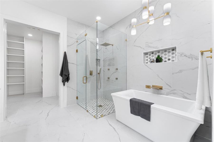 Bathroom featuring a freestanding tub, a marble finish shower, stone wall, marble tiled flooring, and recessed lighting