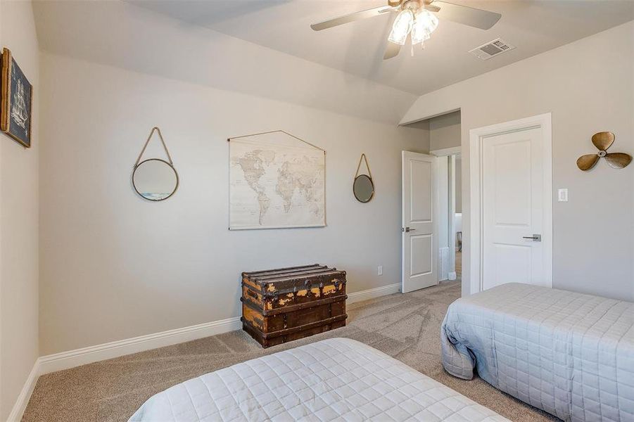 Bedroom featuring lofted ceiling, ceiling fan, and carpet flooring