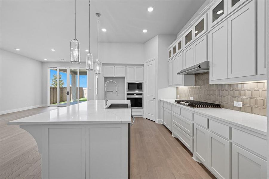Kitchen featuring white cabinets, recessed lighting, light stone countertops, stainless steel appliances, and light wood-style floors Kitchen featuring white cabinets, recessed lighting, light stone countertops, stainless steel appliances, and light wood-style floors