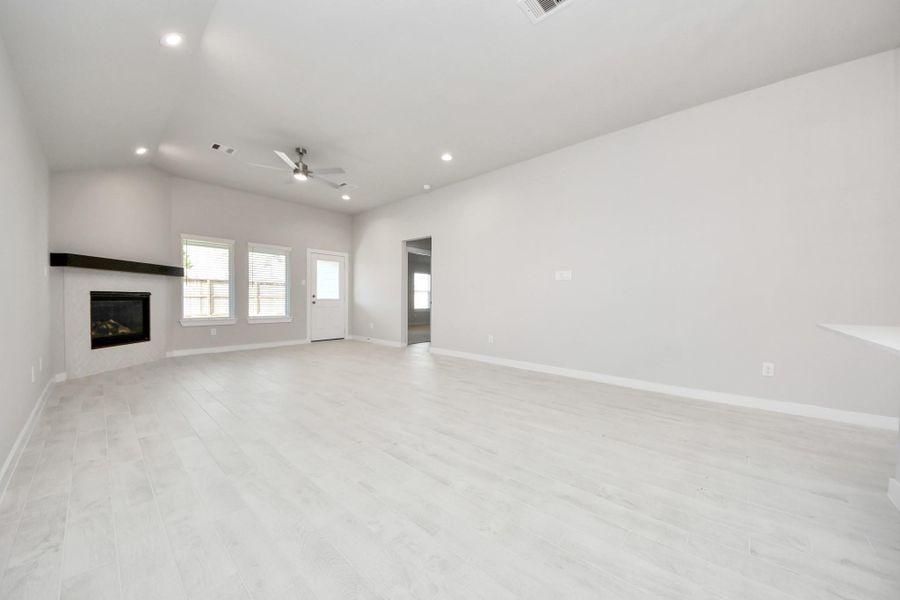 Gather the family and guests together in your lovely living room! Featuring soaring high ceilings, recessed lighting, ceiling fan, custom paint, gorgeous floors, and large windows that provide plenty of natural lighting throughout the day. Sample photo of completed home with similar floor plan. Actual colors and selections may vary.