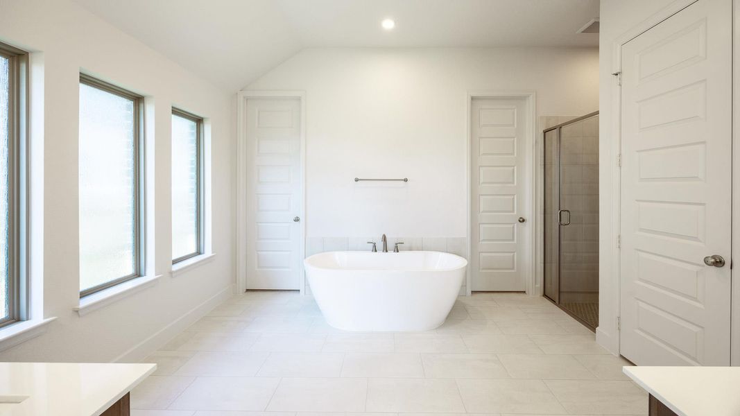 Full bathroom with vanity, a freestanding bath, a shower stall, light tile patterned floors, and recessed lighting Full bathroom with vanity, a freestanding bath, a shower stall, light tile patterned floors, and recessed lighting