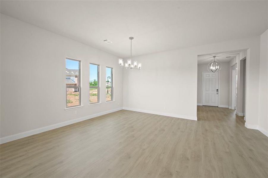 Empty room featuring a chandelier and light wood finished floors