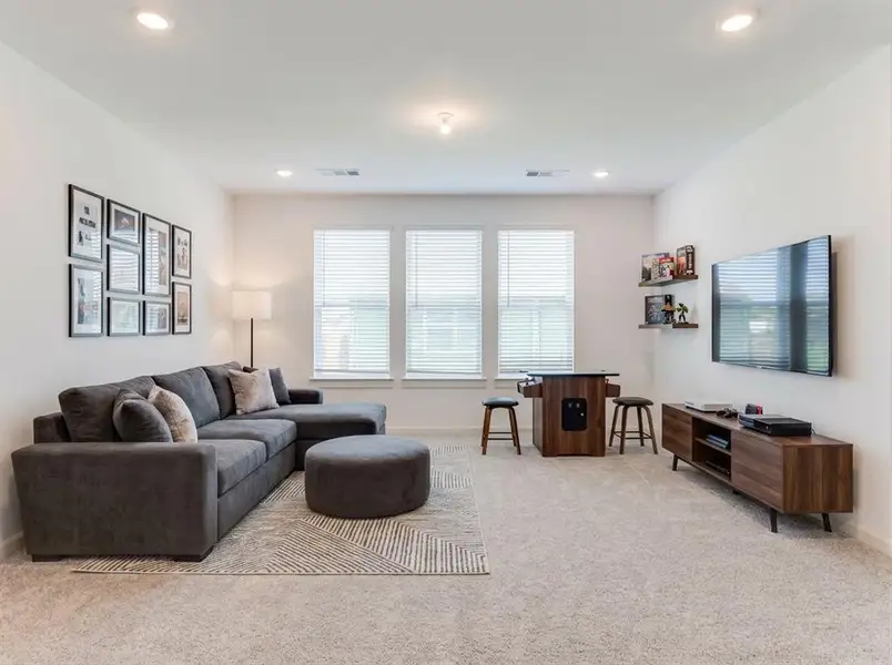 Spacious room featuring light-toned carpeting and recessed lighting