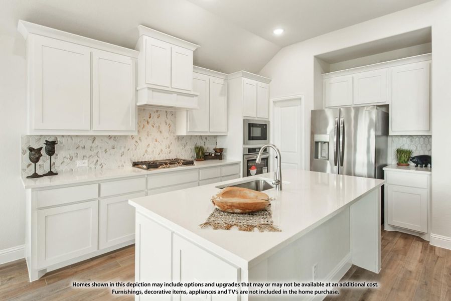 Kitchen with white cabinets, center island with sink, stainless steel appliances, and decorative tile backsplash