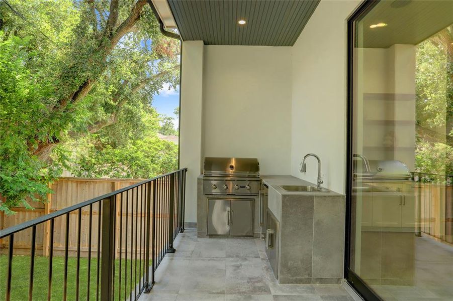 The Back Patio features a Summer Kitchen with high-end Coyote gas grill, sink, counterspace for food preparation and a beverage fridge.