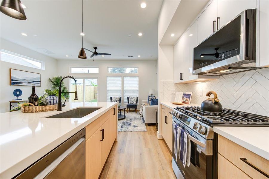 This luxurious kitchen comes with smart appliances, white quartz waterfall counters, modern European style soft-close cabinetry, walk-in pantry, and more! Fridge included!