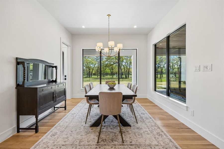 This inviting dining area offers stunning views, allowing you to enjoy the natural beauty of the expansive greenbelt and the comfort of the adjacent covered patio, creating a perfect setting for meals and relaxation.