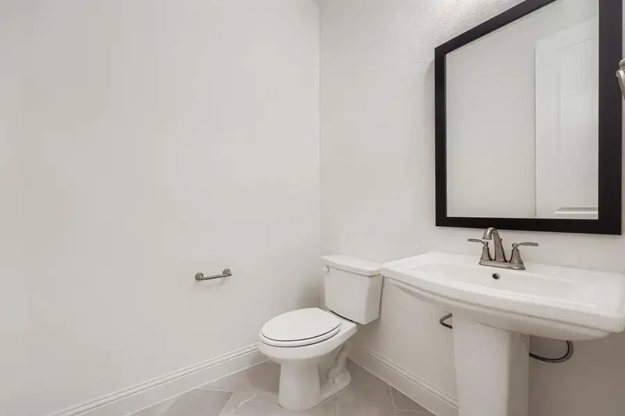 Half bathroom with baseboards and light tile patterned floors